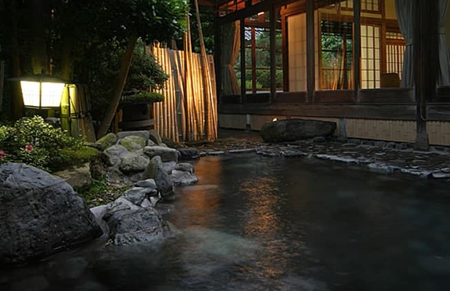 An open-air bath ringed by garden