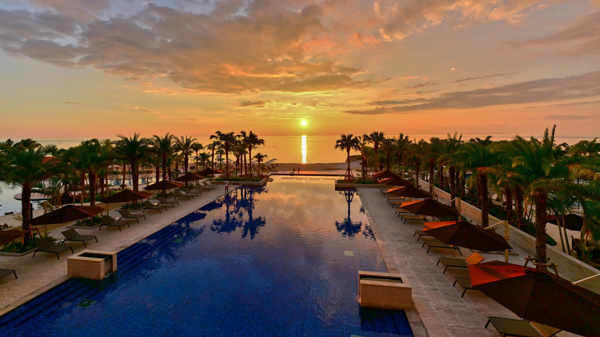 The sun sets in front of the hotel at sunset time.