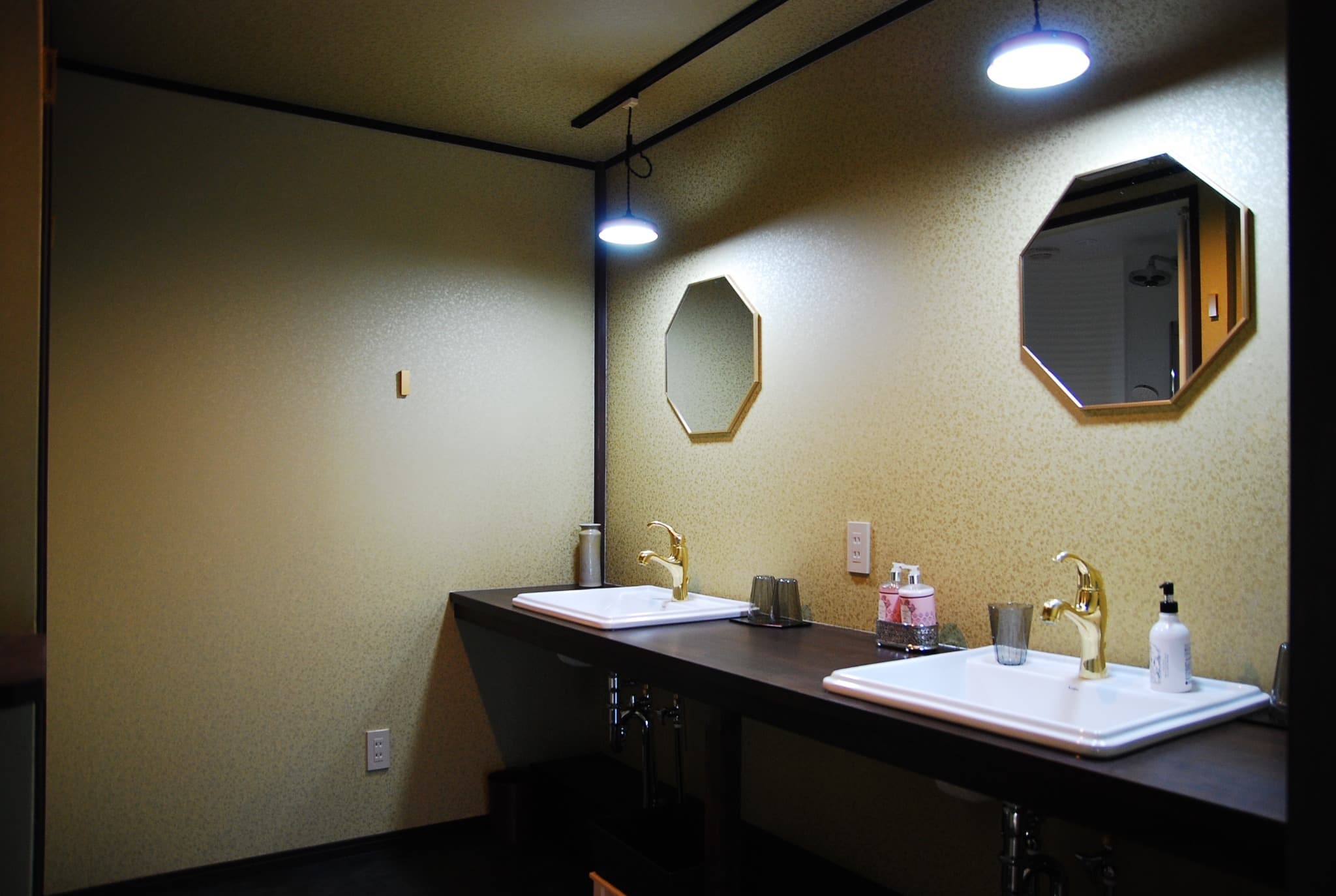 Octagonal mirror and gold wallpaper washroom