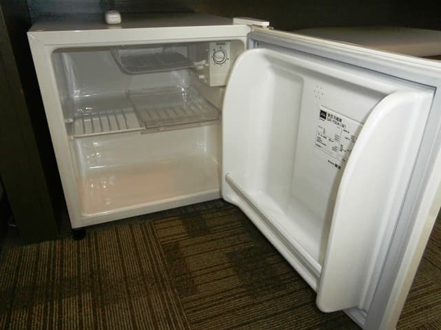 There is an empty refrigerator in the room.