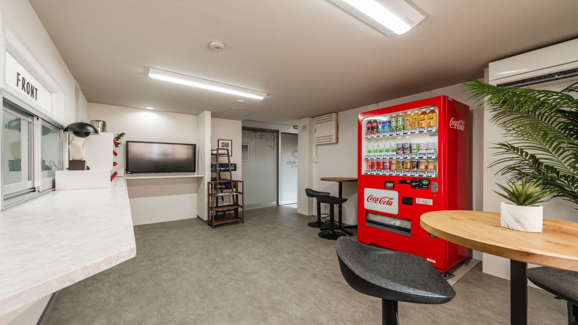 [1st Floor Shared Space] There are relaxing cafe tables next to the front desk.